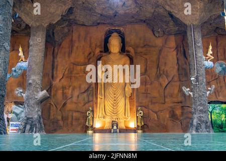 THAILAND, 11 2022. JUNI, Eine Steinskulptur des stehenden Buddha in Abhaya Mudra Geste im buddhistischen Tempel Maniwong Stockfoto