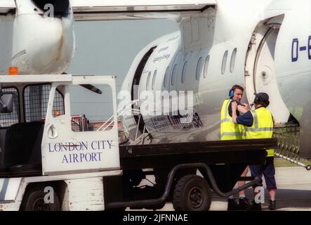 Bodenpersonal am Flughafen London City bereitet Flugzeuge für den Flug am Gate vor. Stockfoto
