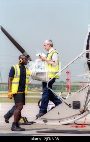 Bodenpersonal am Flughafen London City bereitet Flugzeuge für den Flug am Gate vor. Stockfoto