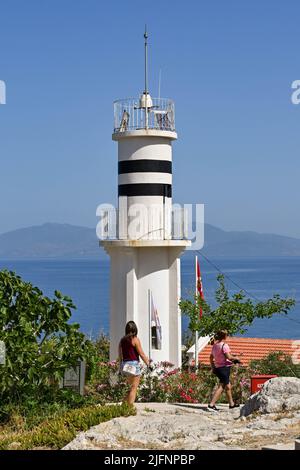 Kusadasi, Türkei - Juni Mai 2022: Besucher, die am historischen Leuchtturm auf Pigeon Island im Hafen von Kusadasi vorbeilaufen. Stockfoto