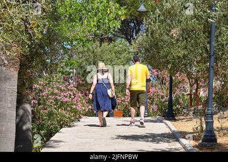 Kusadasi, Türkei - Juni 2022: Besucher, die am Leuchtturm auf der Pigeon Island im Hafen von Kusadasi vorbeilaufen. Stockfoto
