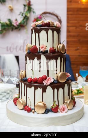 Dreistufiger Hochzeitstorte mit Obst und Schokolade. Stockfoto