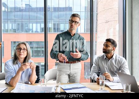 CEO Mentor Leader diskutiert Bericht mit Kollegen bei der Besprechung im Vorstandszimmer. Stockfoto