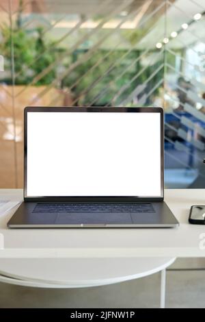 Arbeitsplatz im modernen Büro mit weißem leerem PC-Laptop-Computer mit aufgearbeittem Bildschirm. Stockfoto