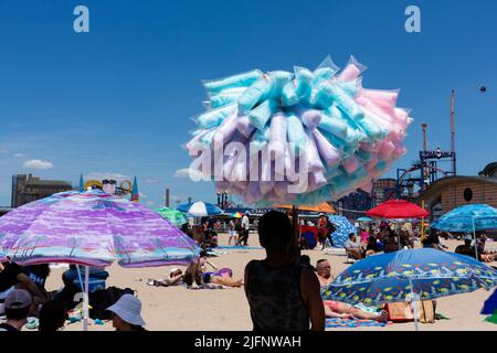 Coney Island, NY, USA. 4.. Juli 2022. Der Strand und die Promenade von Coney Island sind voller Menschen, als New York den 4. Juli feiert. Ein Anbieter von Zuckerwatte am Strand. Quelle: Ed Lefkowicz/Alamy Live News Stockfoto