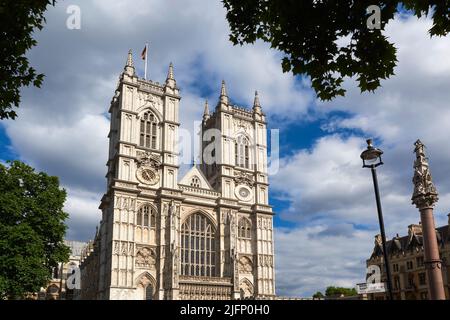 Die Türme an der Westfassade der Westminster Abbey, im Zentrum von London, Großbritannien, blicken nach oben, mit umliegenden Bäumen Stockfoto