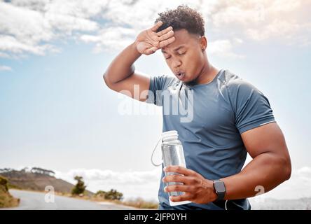 Ein gesundes Außen beginnt von innen. Aufnahme eines Mannes, der während des Trainings Wasser trinkt. Stockfoto