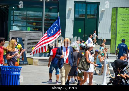 New York, Usa. 04.. Juli 2022. Während der jährlichen Indepedence Day Parade am 4. Juli 2022 im South Street Seaport in New York City wird ein Mann mit der US-Flagge zu Fuß beobachtet. (Foto von Ryan Rahman/Pacific Press) Quelle: Pacific Press Media Production Corp./Alamy Live News Stockfoto