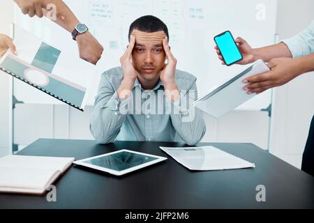 Ich habe das Gefühl, dass meine Zeit knapp wird. Porträt eines jungen Geschäftsmannes, der gestresst in einer anspruchsvollen Büroumgebung arbeitet. Stockfoto
