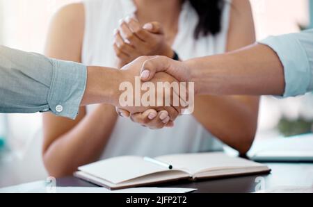 Gemeinsam ihre Träume wahr werden lassen. Nahaufnahme von Geschäftsleuten, die sich während einer Besprechung in einem Büro die Hände schüttelten. Stockfoto