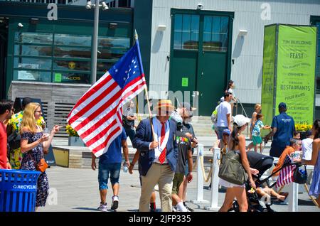 New York, New York, USA. 4.. Juli 2022. Während der jährlichen Indepedence Day Parade am 4. Juli 2022 im South Street Seaport in New York City wird ein Mann mit der US-Flagge zu Fuß beobachtet. (Bild: © Ryan Rahman/Pacific Press via ZUMA Press Wire) Stockfoto