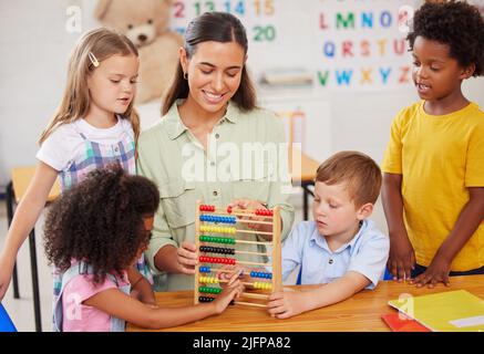 Spielfreiheit gibt Kindern die Möglichkeit, ihre Neugier zu erweitern. Aufnahme einer jungen Frau, die eine Klasse von Vorschulkindern unterrichtet. Stockfoto