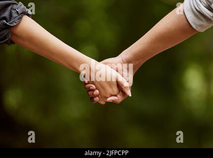 Ein Spaziergang auf der wilden Seite. Nahaufnahme eines unverkennbaren Paares, das Hand in Hand durch die Wildnis geht. Stockfoto