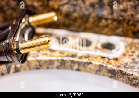 Ersetzen eines Waschbecken Wasserhahn durch eine neue Baugruppe. Stockfoto