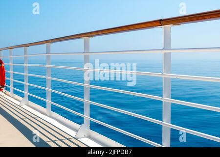 Blick auf das blaue Meer und den Himmel vom oberen Promenadendeck eines Kreuzschiffs auf See. Stockfoto