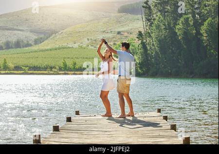 Mein Herz schlägt für dich. Aufnahme eines jungen Paares, das sich auf einem Steg an einem See festklebte. Stockfoto