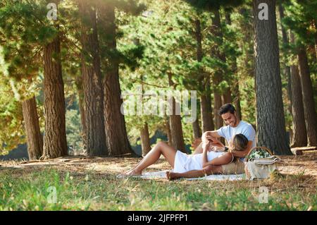 Ein Picknick im Wald stellt alles wieder her. Aufnahme eines jungen Paares, das im Wald ein Picknick gemacht hat. Stockfoto