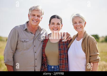 Alles, was ich bin, ist den Eltern zu verdanken. Aufnahme einer jungen Frau auf einem Bauernhof mit ihren älteren Eltern. Stockfoto