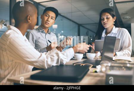 Die besten Pläne werden gründlich gemacht. Aufnahme einer Gruppe von Geschäftsleuten, die spät in einem modernen Büro arbeiten. Stockfoto