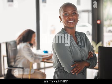Ein stolzer Geschäftsinhaber. Aufnahme einer jungen Geschäftsfrau, die bei der Arbeit mit gekreuzten Armen steht. Stockfoto