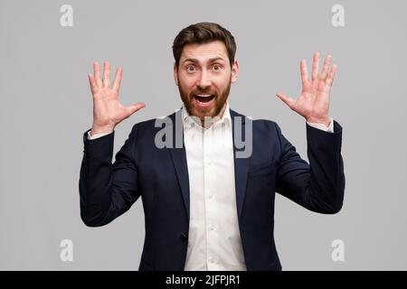 Emotionaler männlicher Business Coach in Anzug legt seine Hände hoch und schreit Stockfoto