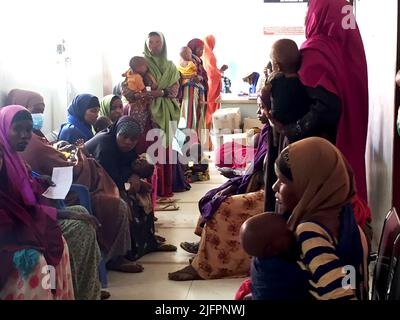 Baidoa, Somalia. 29.. Juni 2022. Mütter warten mit ihren Kindern im Bardalle Health Center in Baidoa im Südwesten Somalias auf eine Untersuchung ihrer Kleinen. Das Land am Horn von Afrika erlebt seit Monaten eine schwere Dürre, nachdem vier aufeinanderfolgende Regenzeiten nicht eingetreten sind. Insbesondere Säuglinge sind dem Hungerrisiko ausgesetzt. (To dpa 'Wettlauf gegen die Zeit, um das Leben hungernder Kinder zu retten') Quelle: Eva-Maria Krafczyk/dpa/Alamy Live News Stockfoto