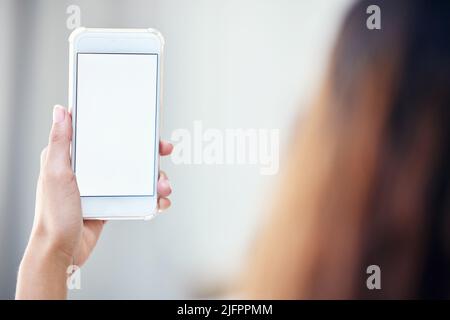 Alles, was Sie im Internet tun, hinterlässt Spuren. Nahaufnahme einer nicht erkennbaren Frau, die ein Mobiltelefon mit einem leeren Bildschirm in der Hand hält. Stockfoto