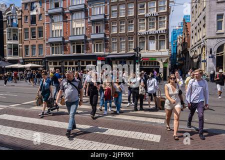 Amsterdam, Niederlande - 21. Juni 2022: Viele Menschen überqueren die Straße in Amsterdam Stockfoto