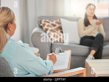 Psychische Erkrankungen sind keine Wahl, aber Genesung ist es. Aufnahme eines Psychologen, der sich während einer Konsultation Notizen macht. Stockfoto