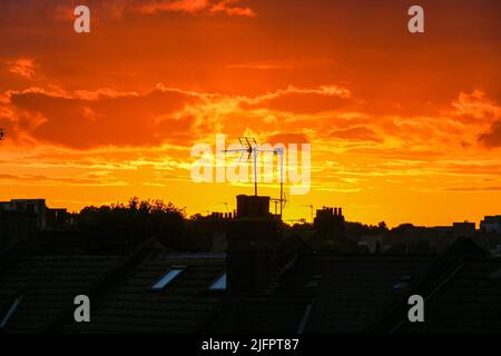 London, Großbritannien. 1.. Juli 2022. Silhouette eines Schornsteins und einer Fernsehantenne gegen den goldfarbenen Sonnenuntergang. (Bild: © Dinendra Haria/SOPA Images via ZUMA Press Wire) Stockfoto