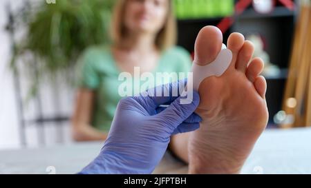 Arzt Orthopäde untersucht Bein mit Hallux Valgus-Deformität der ersten Zehe Stockfoto