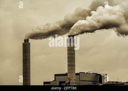 Kamine und dunkler Rauch, der aus einer Fabrik kommt Stockfoto