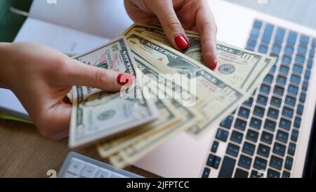 Frau, die Bargeld in der Hand hält und Banknoten zählt Stockfoto