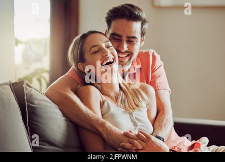 Lachen macht unsere Bindung stärker. Aufnahme eines jungen Paares, das zu Hause Zeit zusammen verbringt. Stockfoto