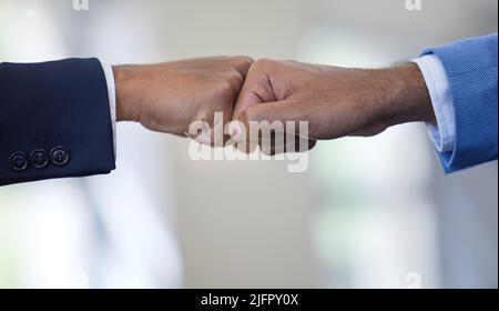 Wir haben das verstanden. Nahaufnahme von zwei unkenntlichen Geschäftsleuten, die sich in einem Büro gegenseitig eine Faust-Beule geben. Stockfoto