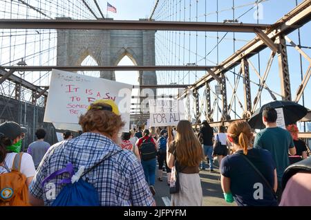 New York, New York, USA. 4.. Juli 2022. Hunderte halten am 4. Juli 2022 Zeichen, während sie über die Brooklyn Bridge, New York City, marschieren, um Gerechtigkeit für Abtreibung und andere soziale Probleme zu fordern. (Bild: © Ryan Rahman/Pacific Press via ZUMA Press Wire) Stockfoto