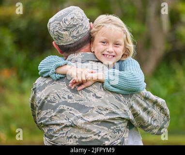 Eine Familie, die sich gegenseitig unterstützt, gedeiht. Aufnahme eines Vaters, der aus der Armee zurückkehrt und seine Tochter draußen umarmt. Stockfoto