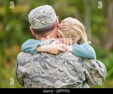 Die Familie ist da, um Sie zu unterstützen und Ihre Entscheidungen zu respektieren. Aufnahme eines Vaters, der aus der Armee zurückkehrt und seine Tochter draußen umarmt. Stockfoto