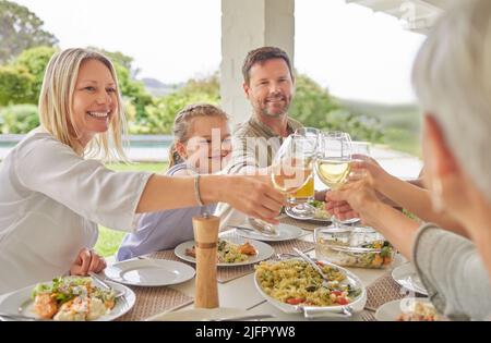 Zu Gesundheit und Wellness. Aufnahme einer Familie beim Toasten während eines sonntagsmittags. Stockfoto