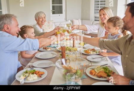 Schätzen Sie die Menschen, die Sie haben. Aufnahme einer Familie beim Toasten während eines sonntagsmittags. Stockfoto