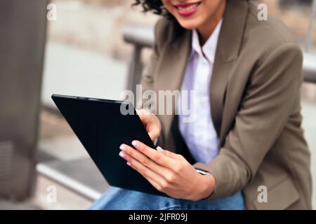 Nicht erkennbare junge Frau, die ein Tablet benutzt Stockfoto