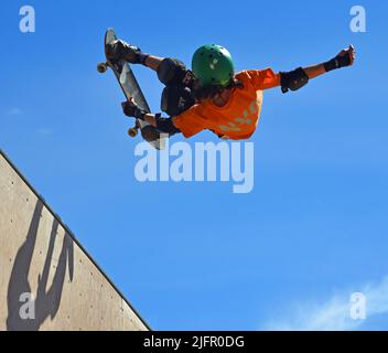 Skateboarder beim Halb-Stunt auf der Vert-Rampe. Stockfoto