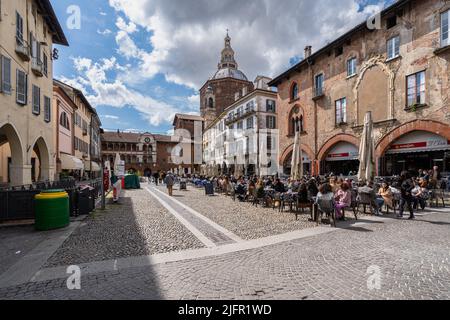 Pavia, Italien, 2022. März - Piazza della Vittoria im historischen Zentrum von Pavia mit der Kuppel der Kathedrale von Pavia und dem Gebäude von Broletto. Stockfoto