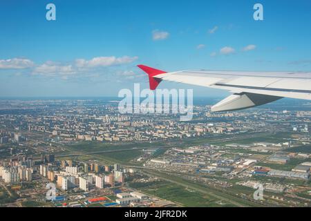 Schöne Aussicht auf die Stadt, wenn das Flugzeug mit dem Flügel abhebt Stockfoto