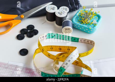 Nähen von Gegenständen und Nähwerkzeugen. Scheren, Maßband, Gewinde, Lineale, Stifte, Knöpfe, Stoff Stockfoto