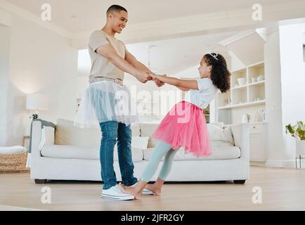 Du spinnst mich richtig um Papa. Aufnahme eines Vaters, der mit seiner Tochter im Wohnzimmer zu Hause tanzt. Stockfoto