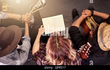 Sicherstellen, dass sie die Musik herunter bekommen. High-Angle-Aufnahme einer nicht erkennbaren Band, die vor einem Auftritt ihre Noten auf der Bühne liest. Stockfoto