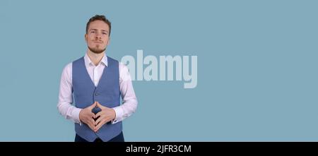 Bild erfolgreicher Mann in formeller Kleidung lächelt an der Kamera, isoliert auf blauem Hintergrund. Stilvoller junger unrasierter Büroangestellter, der im Studio posiert Stockfoto