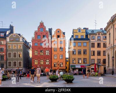 Stockholm, Schweden - 26 2022. Juni: Stortorget, der große Platz, in Gamla Stan, Altstadt, mit traditionellen bunten alten Gebäuden an einem Sommertag mit Touristen und Einheimischen, die in Cafés spazieren gehen und sitzen Stockfoto