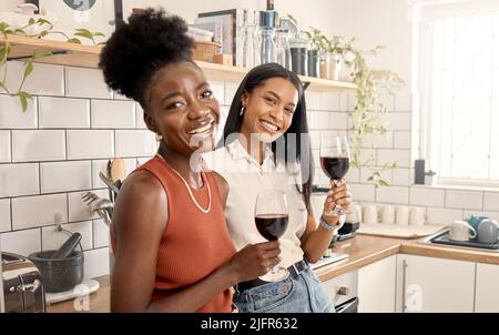 Es ist unser Tag der Verbundenheit. Aufnahme von zwei jungen Freunden, die zu Hause zusammen Wein trinken. Stockfoto